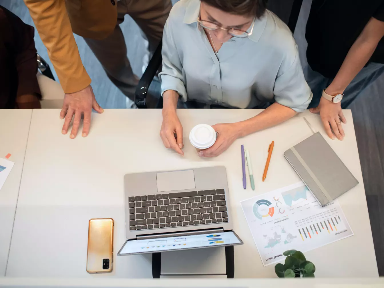 Trzy osoby analizujące wyniki na laptopie Trzy osoby analizujące wyniki na laptopie